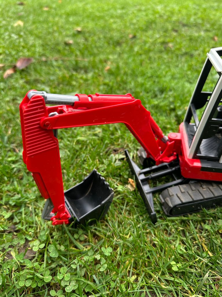 Unser roter Schaeff HR16 Minibagger von Bruder mit Gummiketten.